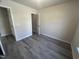 This bedroom offers neutral paint and modern gray laminate flooring throughout at 5520 Neuse View Dr, Raleigh, NC 27610