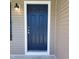 Close-up of a stylish blue front door with white trim and a decorative exterior light fixture at 5520 Neuse View Dr, Raleigh, NC 27610