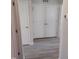 Hallway features multiple white doors with updated flooring at 5520 Neuse View Dr, Raleigh, NC 27610