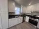 Modern kitchen featuring stainless steel appliances, white cabinetry, and dark countertops at 5520 Neuse View Dr, Raleigh, NC 27610