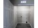 Bright laundry room with gray wood floors and white shelving at 5520 Neuse View Dr, Raleigh, NC 27610