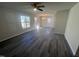 Bright living room with gray wood floors, plenty of natural light, and a modern ceiling fan at 5520 Neuse View Dr, Raleigh, NC 27610
