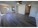 Open-concept living area with gray wood floors, a ceiling fan, and seamless access to the kitchen at 5520 Neuse View Dr, Raleigh, NC 27610