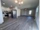 Inviting living space with gray wood floors that flow into a modern kitchen with stainless steel appliances at 5520 Neuse View Dr, Raleigh, NC 27610