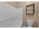 Clean bathroom featuring a white shower and tub combo, a modern toilet, and shelving for storage at 5618 Wade Park Blvd, Raleigh, NC 27607