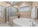 Bathroom featuring a glass shower, soaking tub with tile surround, and natural light from the window at 5618 Wade Park Blvd, Raleigh, NC 27607