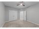 Bright bedroom with fresh gray paint, ceiling fan, carpet, and a double door closet, offering comfort and style at 5618 Wade Park Blvd, Raleigh, NC 27607