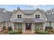 Charming home featuring a covered porch with elegant columns and two chairs, enhancing its curb appeal at 5618 Wade Park Blvd, Raleigh, NC 27607
