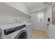 Modern laundry room with white washer and dryer, shelving, and a window for natural light and ventilation at 5618 Wade Park Blvd, Raleigh, NC 27607