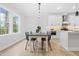 Bright dining area featuring modern lighting, light-colored flooring, and large windows with a view of the outdoors at 605 Shawnee Dr, Louisburg, NC 27549