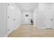 Bright entryway featuring light wood floors, white trim, and a modern front door at 605 Shawnee Dr, Louisburg, NC 27549