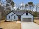 Charming single-story home showcasing a well-manicured lawn, a gray garage door, and light blue siding at 605 Shawnee Dr, Louisburg, NC 27549