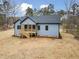 Rear exterior of light blue home featuring a wooden deck and stairs at 605 Shawnee Dr, Louisburg, NC 27549
