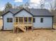 Rear exterior of light blue home featuring a screened-in wooden porch and stairs at 605 Shawnee Dr, Louisburg, NC 27549