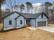 A blue home showcasing a well-manicured lawn, modern design, and an attached garage at 605 Shawnee Dr, Louisburg, NC 27549