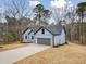 A blue home showcasing a well-manicured lawn, modern design, and an attached garage at 605 Shawnee Dr, Louisburg, NC 27549