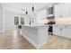 Modern kitchen with white cabinets and countertops with stainless steel appliances and a kitchen island with seating at 605 Shawnee Dr, Louisburg, NC 27549