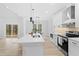 Modern kitchen featuring white cabinets, stainless steel appliances, a spacious island with a sink, and sleek pendant lights at 605 Shawnee Dr, Louisburg, NC 27549