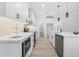 Modern kitchen with white cabinets, countertops and island with stainless steel appliances, and modern light fixtures at 605 Shawnee Dr, Louisburg, NC 27549