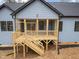 Screened-in wooden porch featuring a wooden railing and stairs at 605 Shawnee Dr, Louisburg, NC 27549