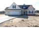 Attractive two-story home featuring a light beige exterior with a dark blue accent gable and a convenient two-car garage at 622 Tart Town Rd, Dunn, NC 28334