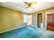 Olive bedroom features a ceiling fan, plush carpet, and access to an ensuite and closet at 623 Rolling Rd, Haw River, NC 27258