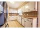 Functional kitchen with white cabinetry, tile countertops, and neutral backsplash at 623 Rolling Rd, Haw River, NC 27258