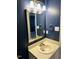 Bathroom with a single sink vanity, framed mirror, and modern lighting at 6520 Thetford Ct, Raleigh, NC 27615