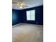 Bedroom featuring neutral carpet, dark blue walls and a well-lit window at 6520 Thetford Ct, Raleigh, NC 27615