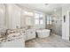 Modern bathroom featuring a soaking tub, double vanity, and glass-enclosed shower at 654 Christian Light Rd, Fuquay Varina, NC 27526
