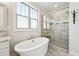 Modern bathroom featuring a soaking tub and glass-enclosed shower at 654 Christian Light Rd, Fuquay Varina, NC 27526