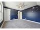 Bedroom with blue accent wall, carpet, ceiling fan, and space themed design at 654 Christian Light Rd, Fuquay Varina, NC 27526