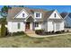 Beautiful white home featuring a welcoming entrance, landscaped yard, and architectural details, creating a charming facade at 654 Christian Light Rd, Fuquay Varina, NC 27526