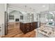 Open kitchen showcasing the center island with bar seating that flows to living area with fireplace and mantle at 654 Christian Light Rd, Fuquay Varina, NC 27526