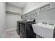 Modern laundry room includes gray washer and dryer, utility sink and storage shelves at 654 Christian Light Rd, Fuquay Varina, NC 27526