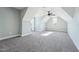 A large, empty living room with gray carpet, vaulted ceilings, a ceiling fan, and natural light from two windows at 654 Christian Light Rd, Fuquay Varina, NC 27526