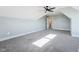 A view into the living room with gray carpet, vaulted ceilings, a ceiling fan, and natural light from two windows at 654 Christian Light Rd, Fuquay Varina, NC 27526