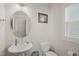 Powder room with pedestal sink, round mirror, window, and neutral walls at 781 Fireball Ct, Knightdale, NC 27545