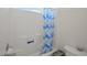 Bright bathroom with a shower/tub combo and blue patterned shower curtain at 781 Fireball Ct, Knightdale, NC 27545