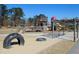 Community playground featuring a tractor tire in sand and a wooden play structure at 781 Fireball Ct, Knightdale, NC 27545