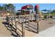 Community playground featuring a wood bridge, play structures, and blue umbrellas at 781 Fireball Ct, Knightdale, NC 27545