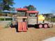 Community playground featuring a red slide and wooden play structure at 781 Fireball Ct, Knightdale, NC 27545