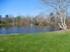 Peaceful pond scene with a fountain, trees, and grassy shoreline, offering a serene view at 781 Fireball Ct, Knightdale, NC 27545