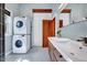Laundry room with white stacked washer and dryer and updated vanity with mirror at 807 Vickers Ave, Durham, NC 27701