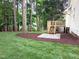 Beautifully landscaped backyard with lush lawn, patio, and fresh mulch. Perfect for relaxing in a tranquil, wooded setting at 904 Amersham Ln, Wake Forest, NC 27587