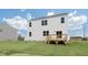 Backyard view with a wooden deck, manicured lawn, and the home's exterior under a partly cloudy sky at 93 Fair Child Rd, Spring Lake, NC 28390