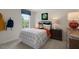 Comfortable bedroom featuring a bed with patterned linens, a window view, and playful decor at 93 Fair Child Rd, Spring Lake, NC 28390