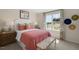 Cozy bedroom with a comfy bed, decorative hats, a window with patterned curtains, and a bench at 93 Fair Child Rd, Spring Lake, NC 28390