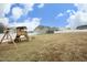 Backyard view featuring playset, green grass, and newer homes, perfect for families and outdoor fun at 97 Buckstone Pl, Willow Springs, NC 27592