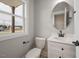 Well-lit bathroom featuring a sleek white vanity, a modern faucet, and an oval mirror at O Shortline Rd, Roxboro, NC 27574